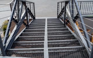 Iron staircase transition between floors. pedestrian ladder above the road, railings made of profile, metal cables stretched between the beams.